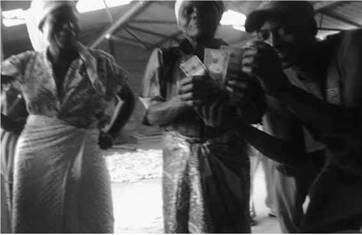 Finger Millett Turns to Money. Members of the community proudly show the U.S. dollars they earned from sale of the golden grain – finger millet grain